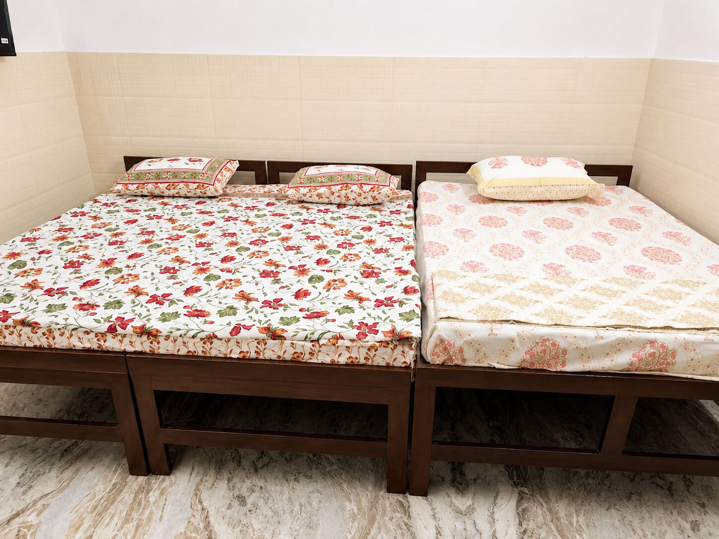 A double bed with floral bedding and a wooden frame.