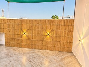 A wooden wall with vertical slats and two wall-mounted lights. - Anantam Stays By Hotel Bhopal Palace (Jaipur)