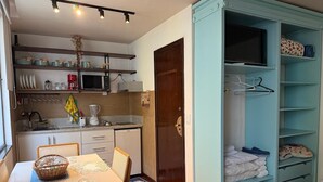 A compact kitchen with a microwave, coffee maker, and a dining area with a table and chairs. - Vista Villa Premium Apartment | Copacabana (Rio de Janeiro)
