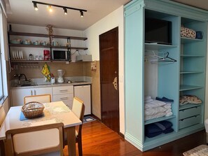 A compact kitchen with a microwave, coffee maker, and a dining area with a table and chairs. - Vista Villa Premium Apartment | Copacabana (Rio de Janeiro)