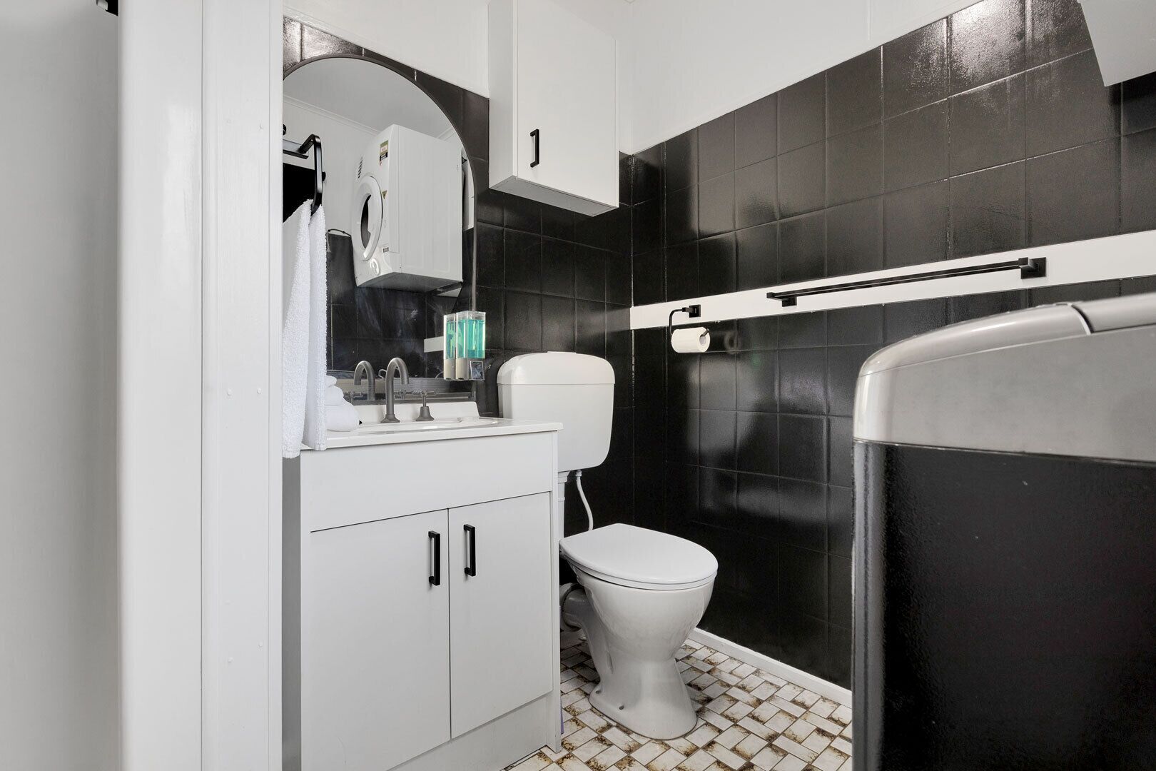 Un baño con inodoro, lavabo y zona de ducha.