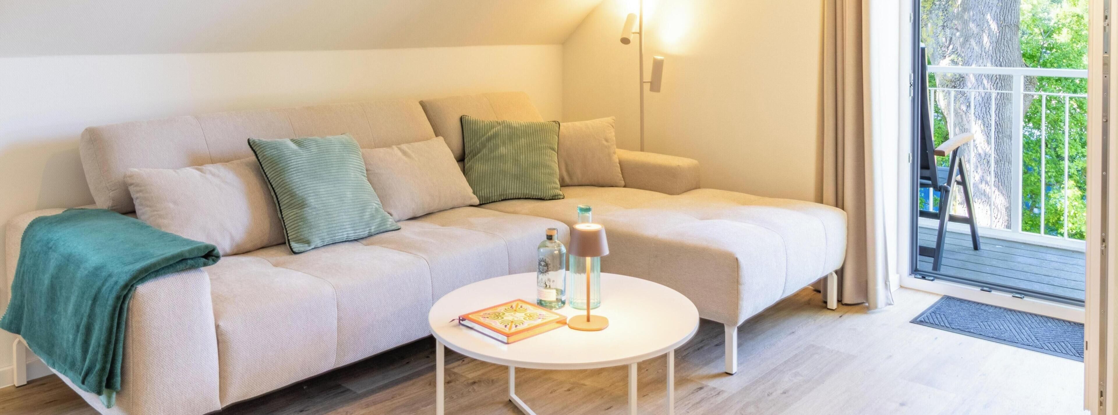 Um quarto acolhedor com um sofá, uma mesinha e vista pela porta.