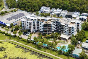 Un moderno complejo hotelero con varias edificaciones, piscina y paneles solares.