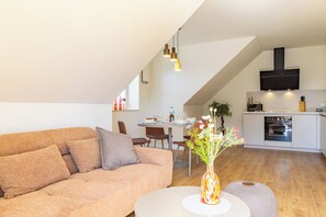 A modern living space with a sofa, a dining table, and a kitchen area. - Tide Resort 2nd Floor - Sauna. Balcony. Meernah. (Tossens)