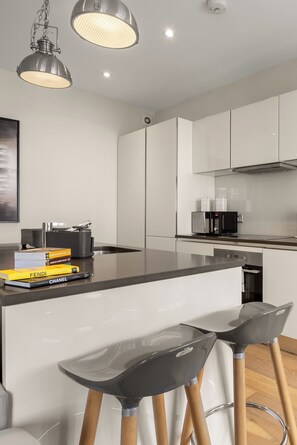 A modern kitchen with a central island, bar stools, and contemporary appliances. - Marble Arch's Gem - Large 2Bed 2Bath (London)