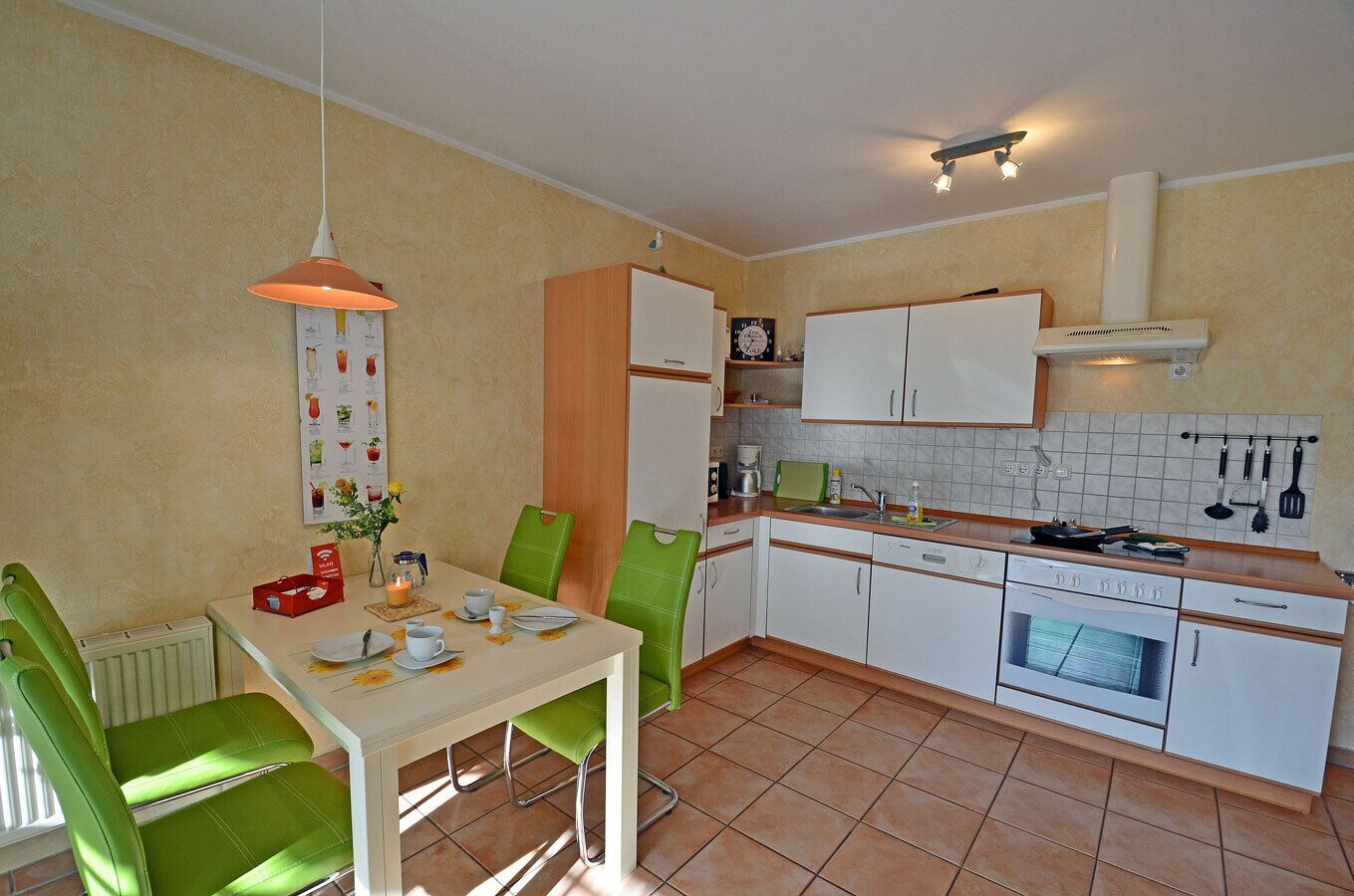 Une cuisine compacte avec un coin repas, comprenant un réfrigérateur blanc, une cuisinière et un évier.
