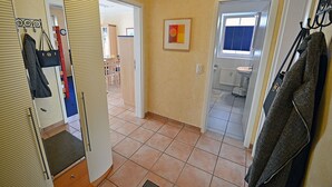 A hallway with a mirror, a coat rack, and a door leading to a bathroom. - Just 50 meters from the sandy Baltic Sea beach, Wi-Fi, washing machine, accommodates up to 4 people, with a balcony (Glowe)