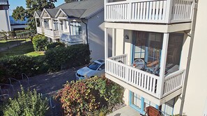 A residential building with a balcony, a car parked in front, and a clear view of the surrounding area. - Just 50 meters from the sandy Baltic Sea beach, Wi-Fi, washing machine, accommodates up to 4 people, with a balcony (Glowe)