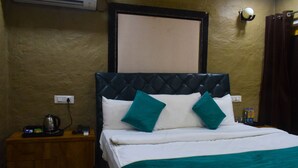 Une chambre d’hôtel équipée d’un lit, d’une table de chevet, d’une bouilloire et d’un climatiseur fixé au mur.