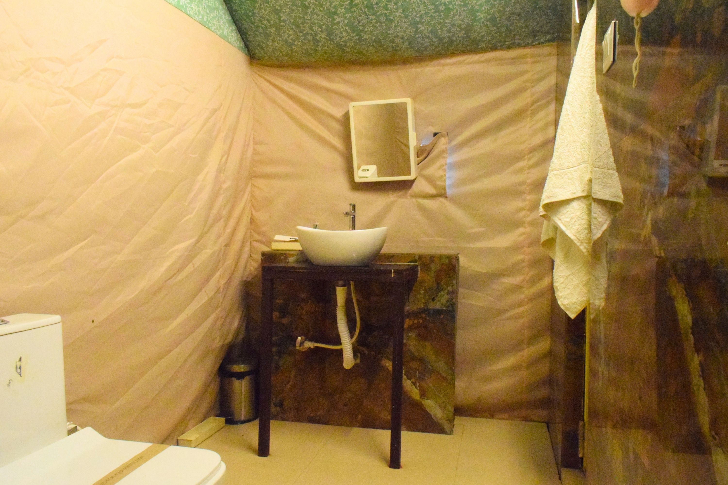 A compact bathroom with a sink, mirror, and towel rack.