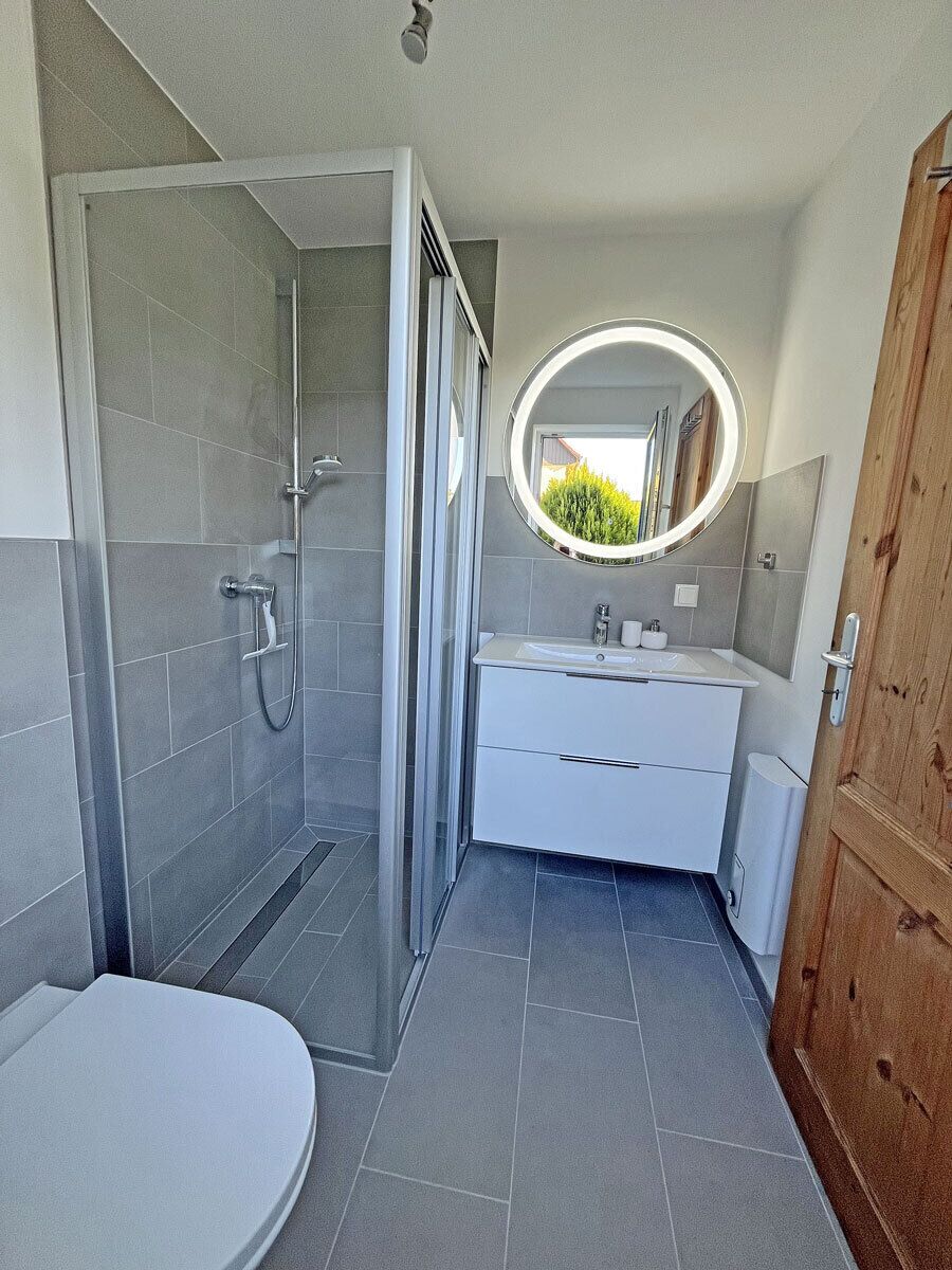 A bathroom with a shower, toilet, and sink.