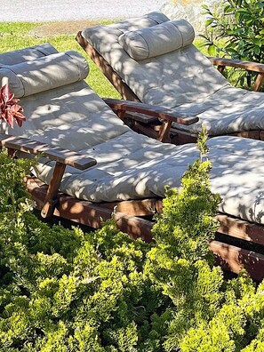 A row of wooden lounge chairs with cushions, surrounded by green shrubs. - 900 meters to the beach, 2 bedrooms, sleeps up to 4, Wi-Fi, pets allowed by arrangement (Breege)