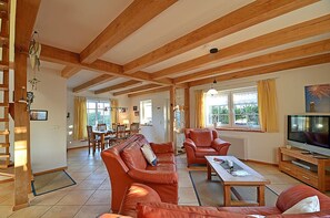 A spacious living room with a wooden ceiling, leather sofas, a dining area, and a television. - 900 meters to the beach, 3 bedrooms, sleeps up to 6, Wi-Fi, pets allowed by arrangement (Breege)
