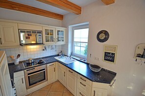 A kitchen with white cabinets, a black countertop, and a window. - 900 meters to the beach, 3 bedrooms, sleeps up to 6, Wi-Fi, pets allowed by arrangement (Breege)