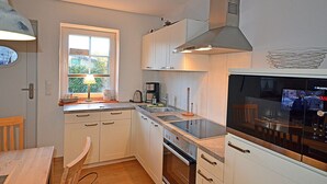 A compact kitchen with white cabinets, a stove, a sink, and a window. - 900 meters to the beach, 2 bedrooms, sleeps up to 4, Wi-Fi, pets allowed by arrangement (Breege)
