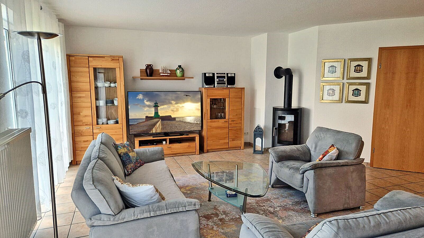 Ein Wohnzimmer mit Fernseher, zwei Sofas, einem Couchtisch und einem Kamin.
