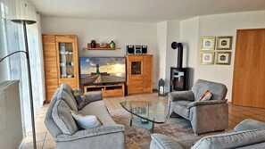 A living room with a television, two sofas, a coffee table, and a fireplace. - About 400 meters from the Baltic Sea beach, with 3 bedrooms, a washing machine, a sauna, and Wi-Fi (Breege)