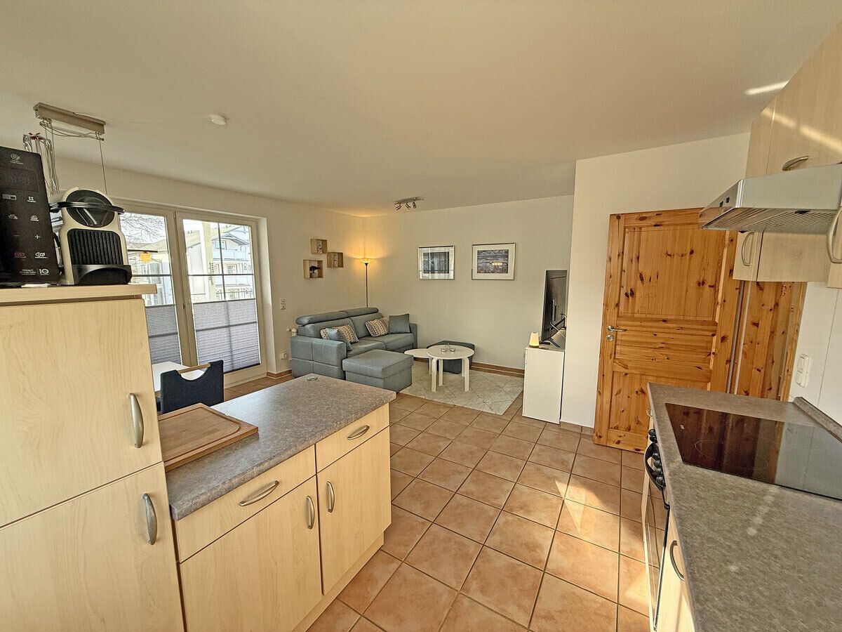A compact kitchen with a dining area, wooden cabinets, a built-in oven, and a small table.
