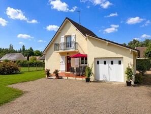 A two-story house with a balcony, a red umbrella, and a garage. - Charming cottage between nature and culture - 6 guests (Thoury)