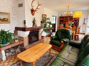 A traditional living room with a fireplace, leather furniture, and a bookshelf. - Charming cottage between nature and culture - 6 guests (Thoury)