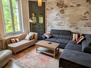 A living room with a sofa, a coffee table, and a patterned rug.