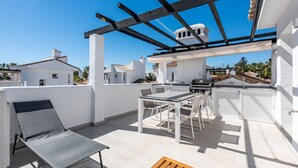 A rooftop patio with a grill, seating, and a pergola. - Modern penthouse with mountain view - 6 guests (Marbella)