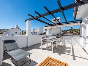 A rooftop patio with a grill, seating, and a pergola. - Modern penthouse with mountain view - 6 guests (Marbella)