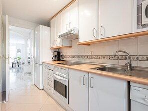 A modern kitchen with white cabinetry, a stainless steel sink, and a Balay dishwasher. - Quiet apartment with terrace - 4 guests (Marbella)