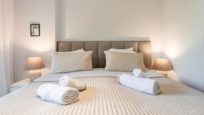 Habitación de hotel con una cama grande, dos lámparas de noche y un cuadro en la pared.