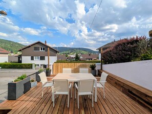 A wooden deck with a table and chairs, surrounded by a low wall and potted plants. - House with mountain view, near center - 6 guests (Gérardmer)
