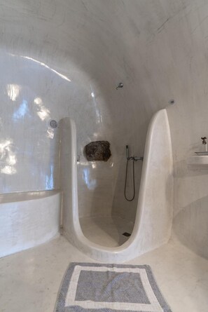 A modern bathroom with a curved shower enclosure, a built-in sink, and a small mirror. - Apartment 'Holiday Home 55sqm' with Wi-Fi and Air Conditioning (Fira)