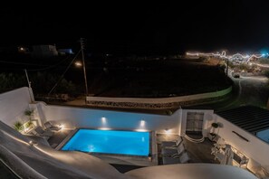 A pool area with a clear blue pool, surrounded by white walls and outdoor seating. - Apartment 'Holiday Home 55sqm' with Wi-Fi and Air Conditioning (Fira)