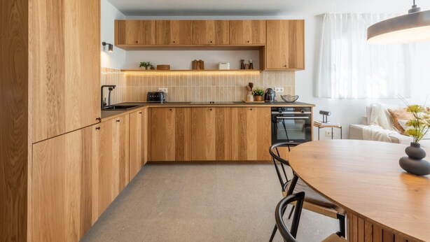 A modern kitchen with wooden cabinets, a central island, and a dining area with a table and chairs. - Modern apartment, panoramic view - 4 guests (Marbella)