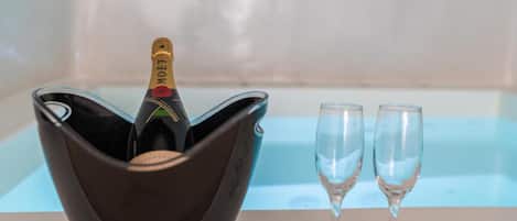 A black cocktail bowl with a bottle of Moët champagne and two empty champagne flutes on a table.