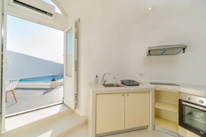 A compact kitchen with a view of the ocean, a built-in oven, and a small sink. - Apartment 'Holiday Home 28sqm' with Wi-Fi and Air Conditioning (Fira)