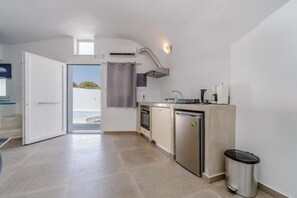 Een kleine keuken met een vaatwasser, oven en een klein spoelgedeelte.