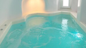 Ein moderner, überdachter Schwimmbereich mit klarem, blauem Wasser, schräg säumiger Decke und einem Dachfenster.