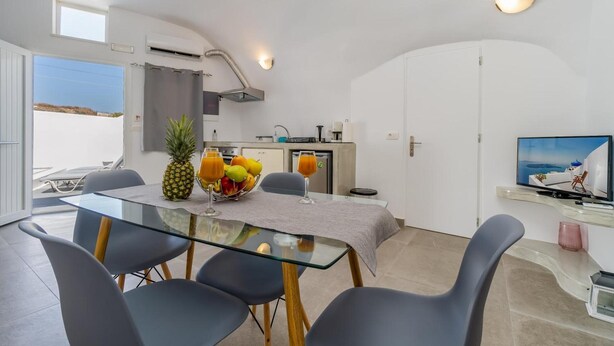 Eine moderne Küche mit Essbereich, einem Fernseher und einem Balkon mit Blick.