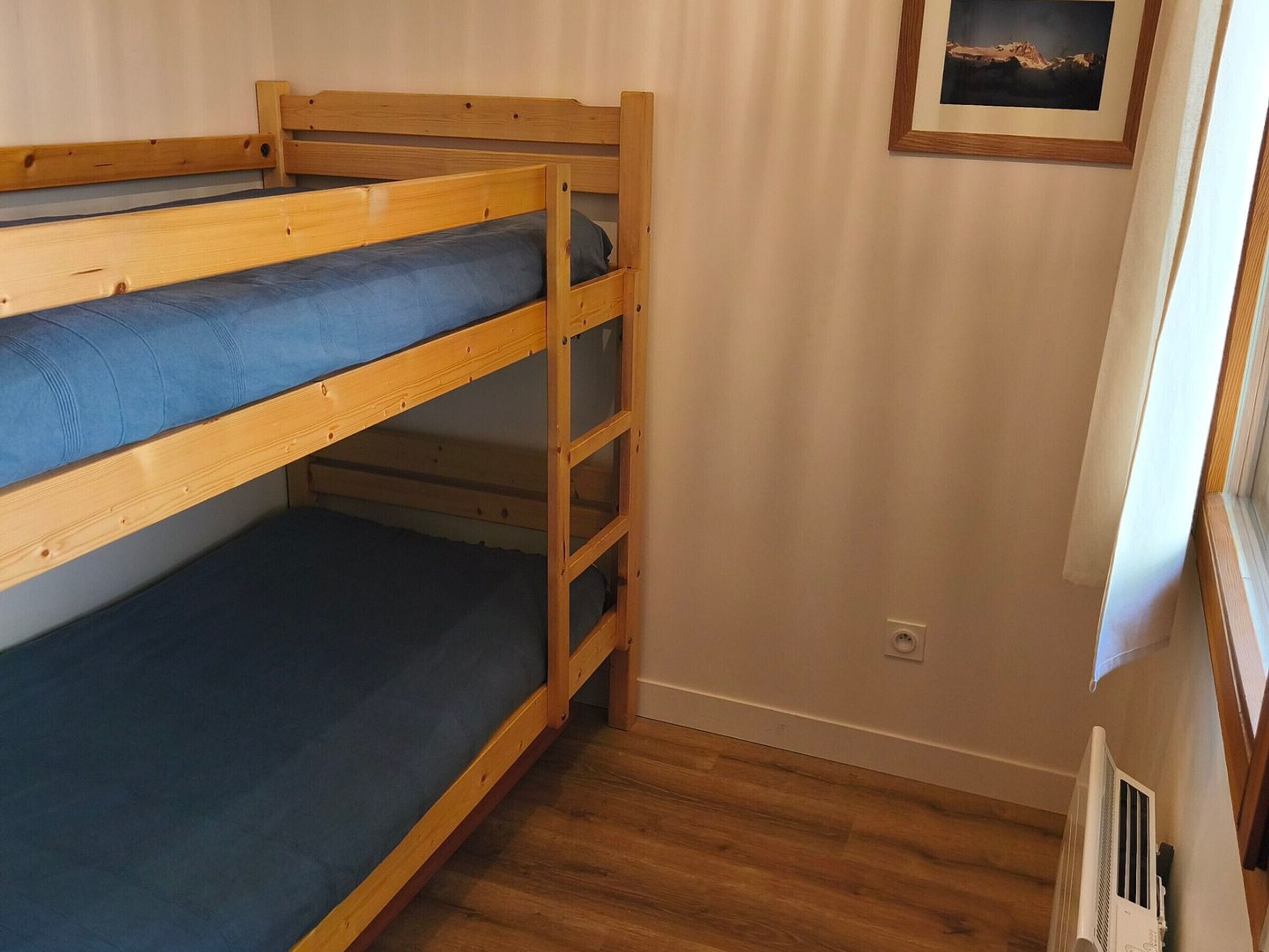 Ein Schlafzimmer mit Etagenbett und einem gerahmten Bild an der Wand.