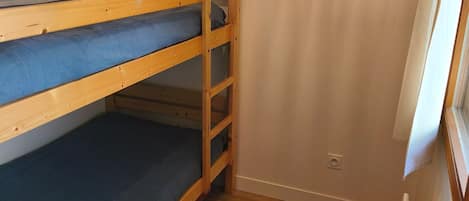 Quarto com beliche e quadro na parede.