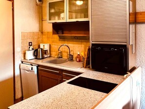 A compact kitchen with a dishwasher, a coffee maker, a sink, and a stove. - Bright duplex near center - 6 guests (Les Gets)
