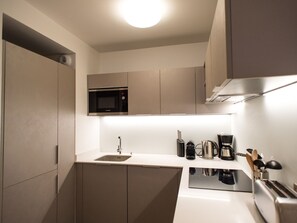 A modern kitchen with a built-in microwave, a sink, and a coffee maker. - Refined apartment in Méribel center - 6 guests (Méribel)