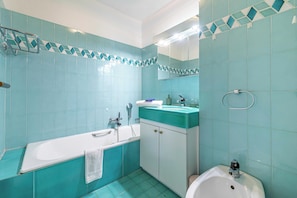 Une salle de bain avec une baignoire, un lavabo et des toilettes.