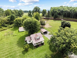 A large house with a spacious lawn and multiple outbuildings, surrounded by dense trees and a hilly landscape. - Frodo's Friendly Farmhouse & Hobbit Homestead.  In Hillsville, VA.  Dog friendly (Hillsville)