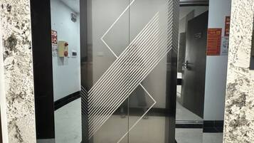 Ein Aufzug mit geometrischem Design an den Türen und einem Marmorboden.