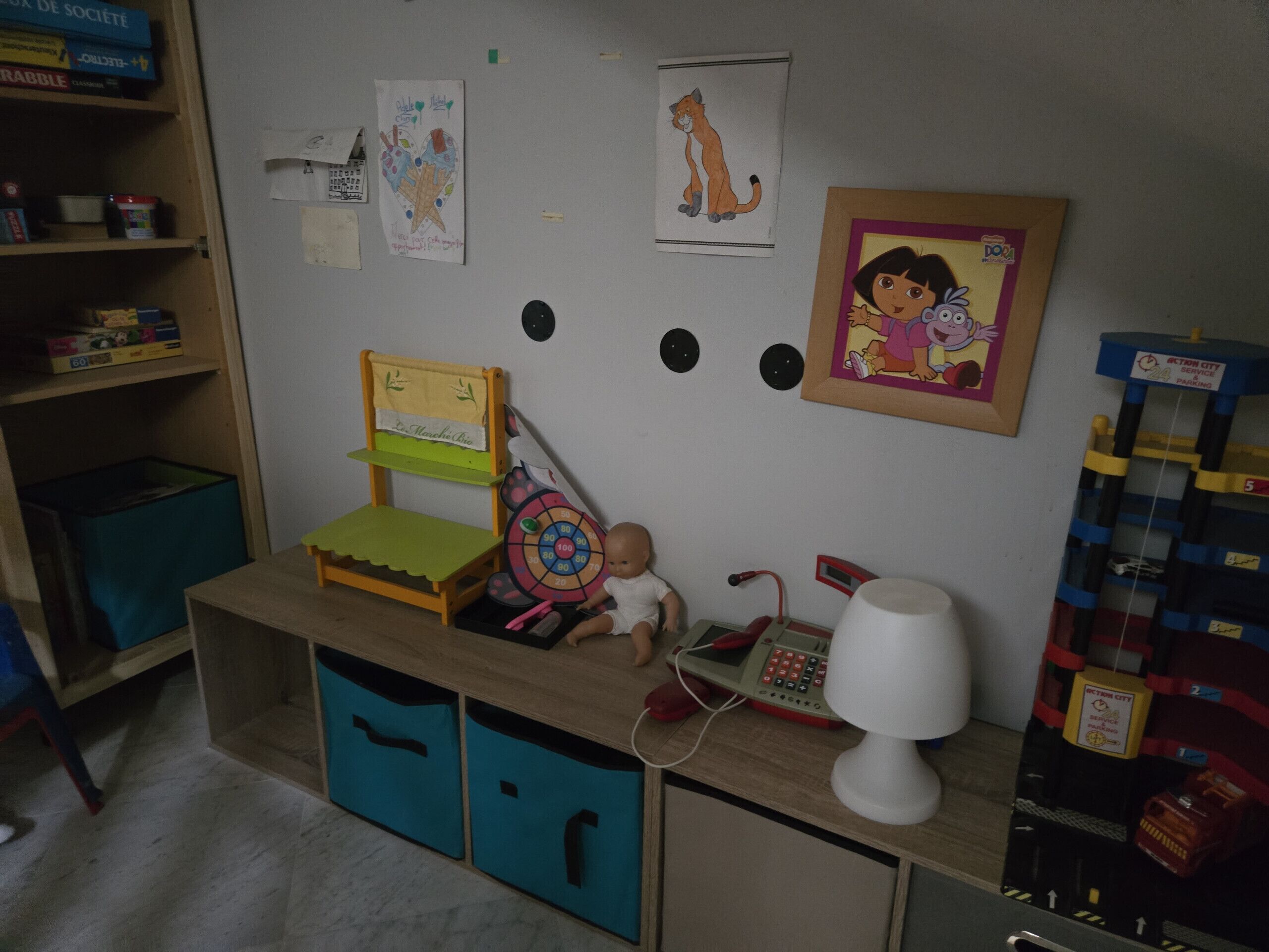 Ein Kinderspielbereich mit Tisch, Stuhl, Aufbewahrungsboxen und Lernspielzeug.