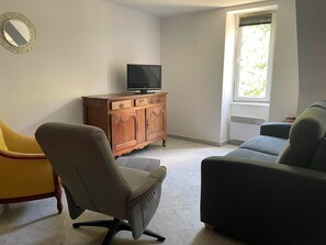 Una sala de estar con un mueble de madera, un televisor y dos sofás.