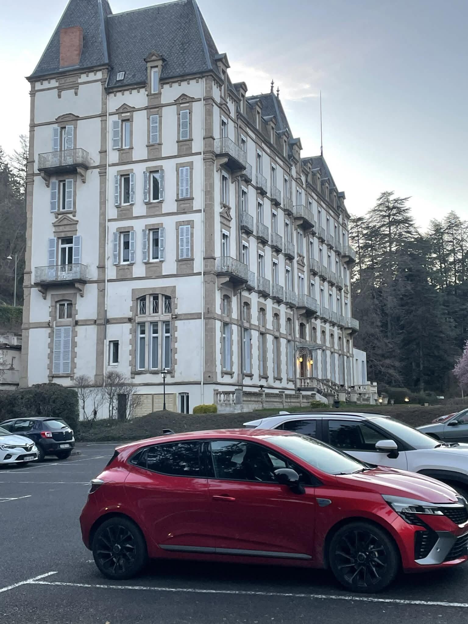 Un immeuble à étages doté d’un style architectural classique, caractérisé par une tour imposante et de nombreuses fenêtres.