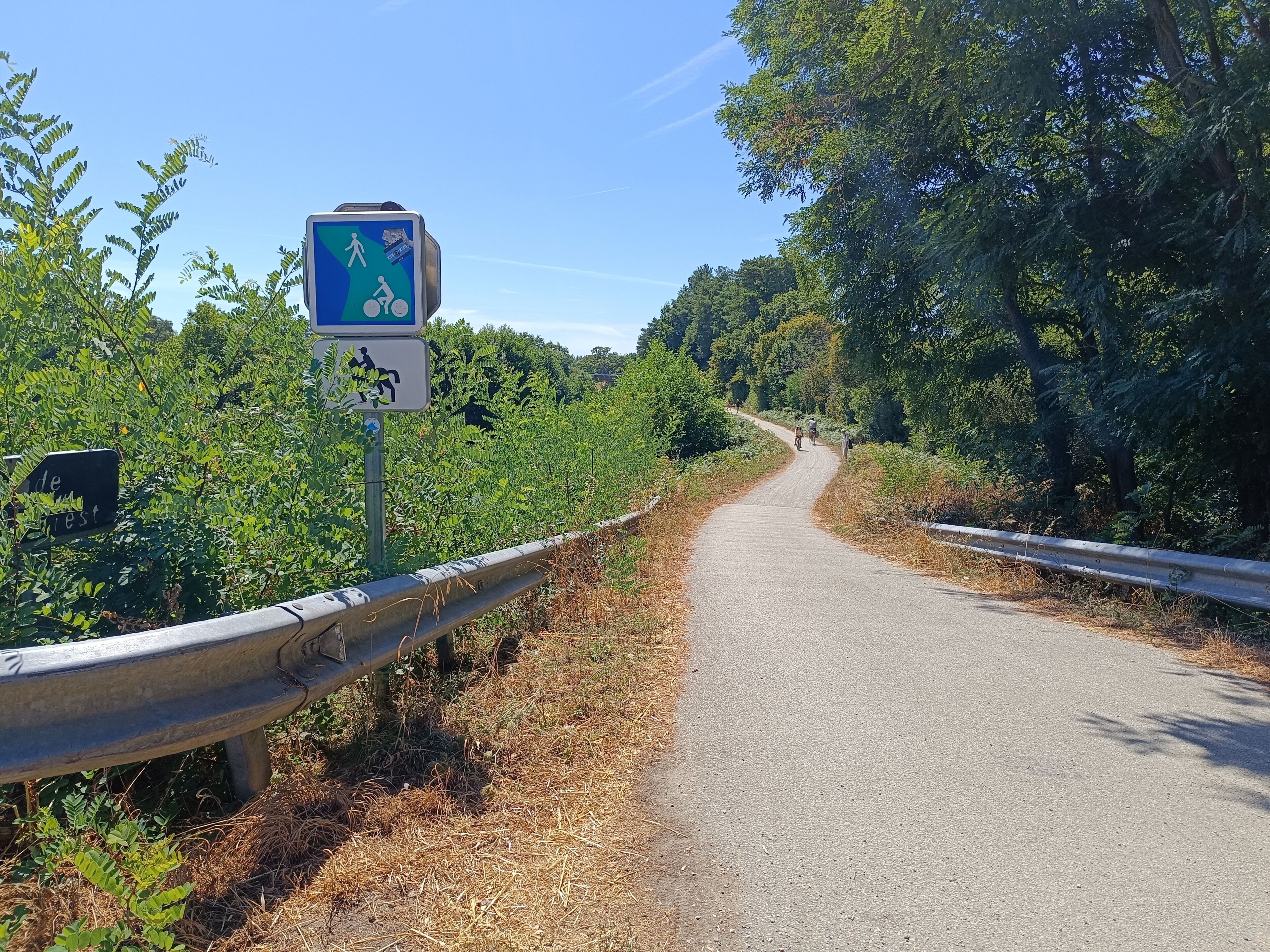 Un chemin pavé, agrémenté d’un panneau bleu indiquant qu’il est réservé aux piétons et aux cyclistes.