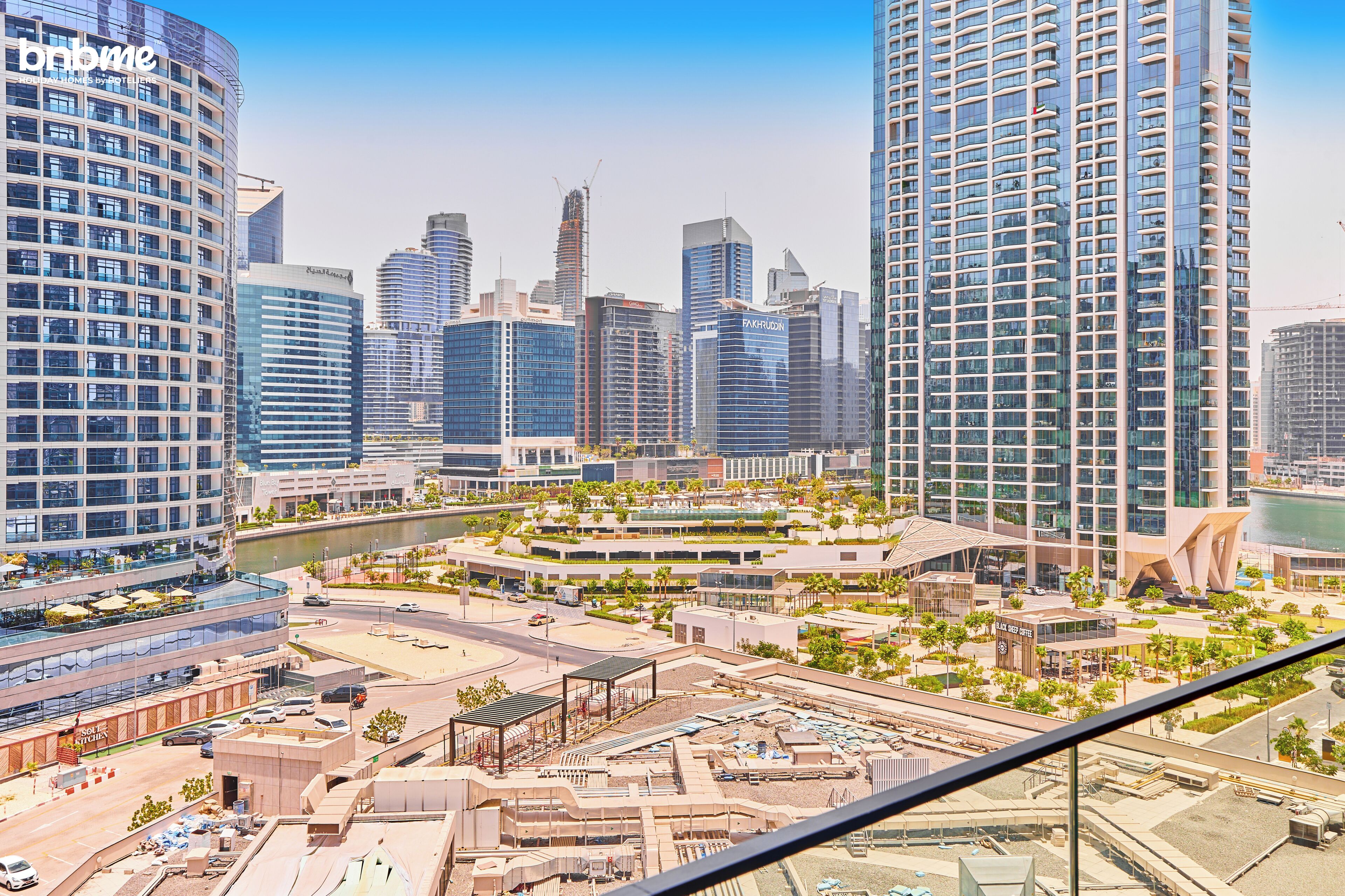 A modern urban landscape with high-rise buildings, a river, and a mix of commercial and residential structures.